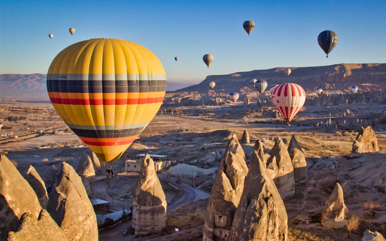 Hot air balloons over Cappadocia's unique rock formations during a 1-hour flight.