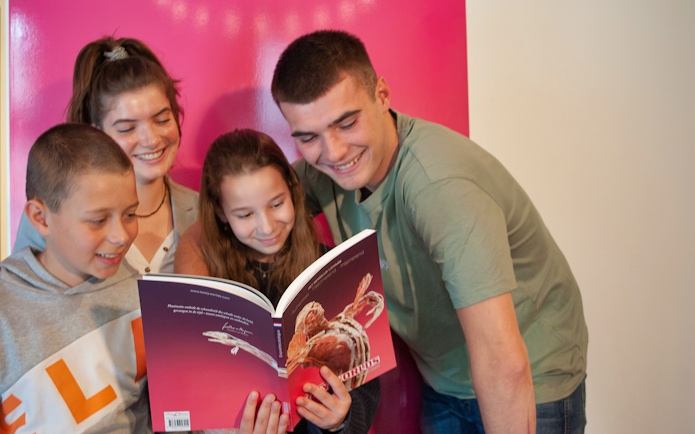 Group of people reading a Body Worlds Amsterdam book together.