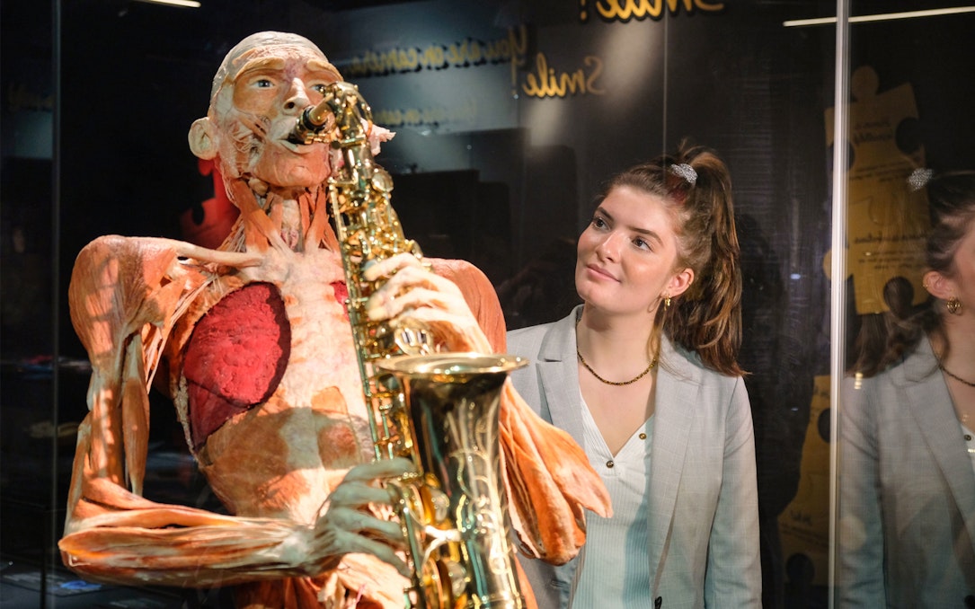 Sculpted human figure playing saxophone at Body Worlds Amsterdam exhibit.