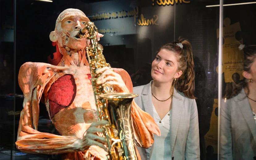 Sculpted human figure playing saxophone at Body Worlds Amsterdam exhibit.