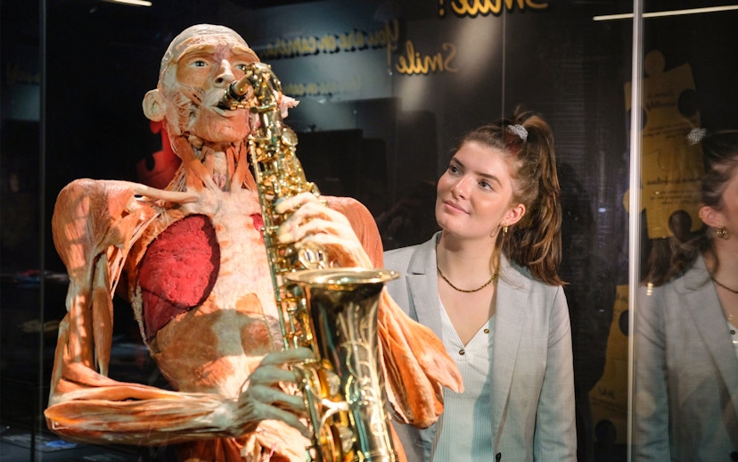 Sculpted human figure playing saxophone at Body Worlds Amsterdam exhibit.