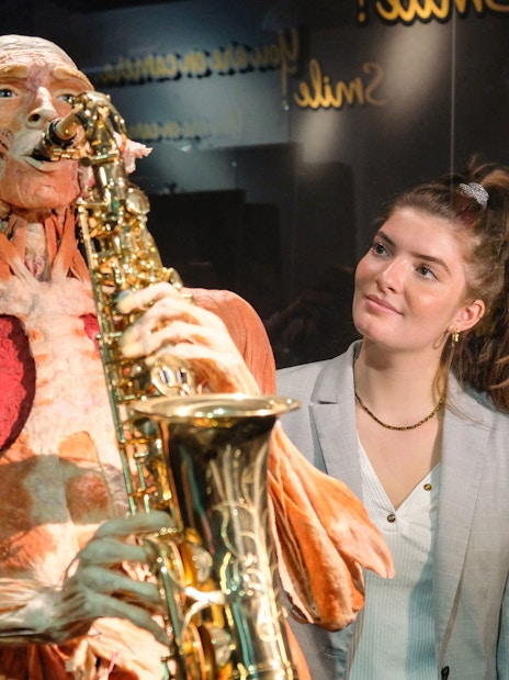 Sculpted human figure playing saxophone at Body Worlds Amsterdam exhibit.