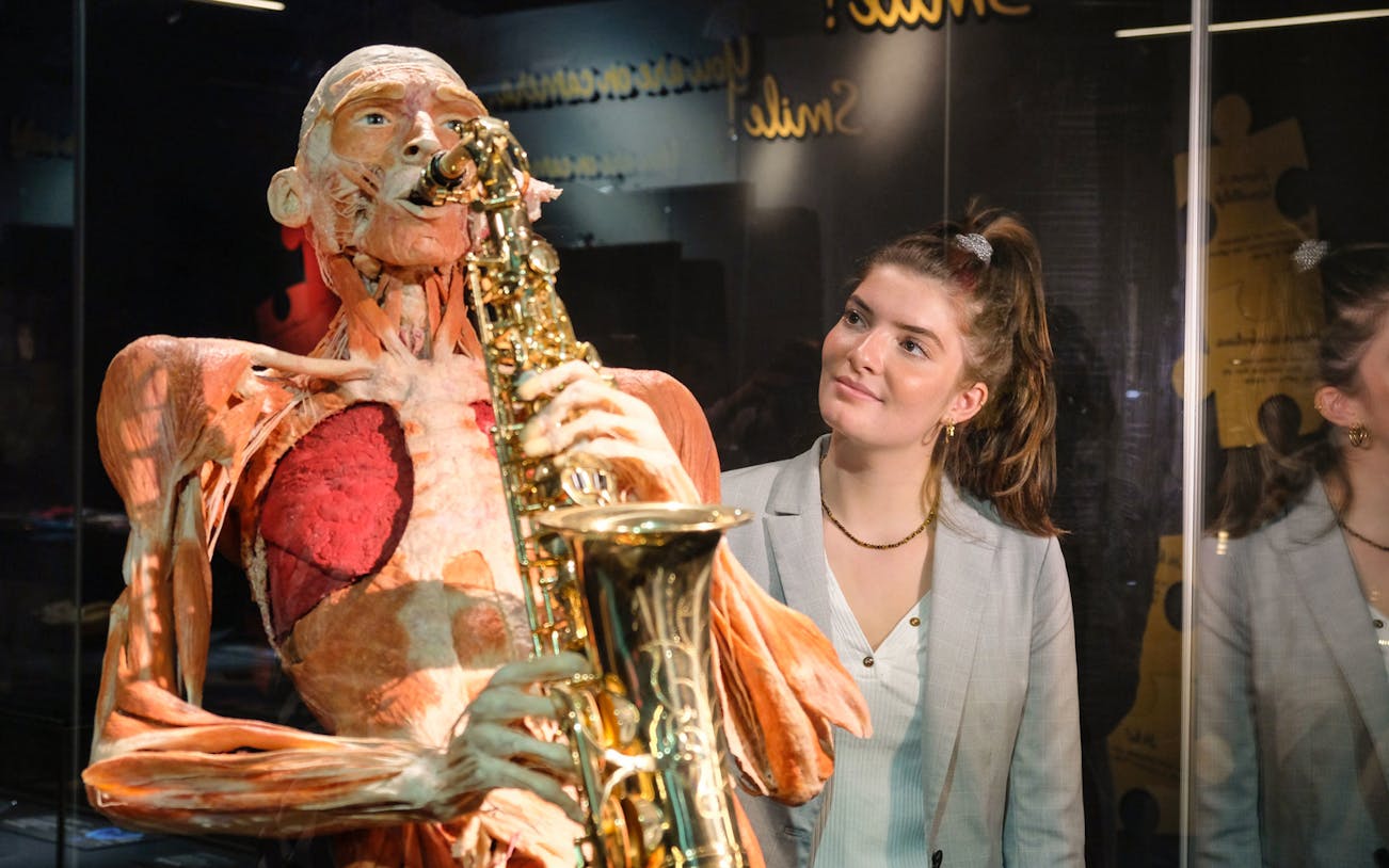 Sculpted human figure playing saxophone at Body Worlds Amsterdam exhibit.