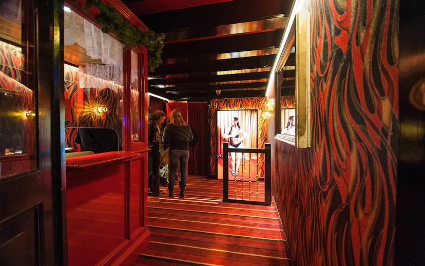 Interior of Museum of Prostitution in Amsterdam with visitors exploring exhibits.