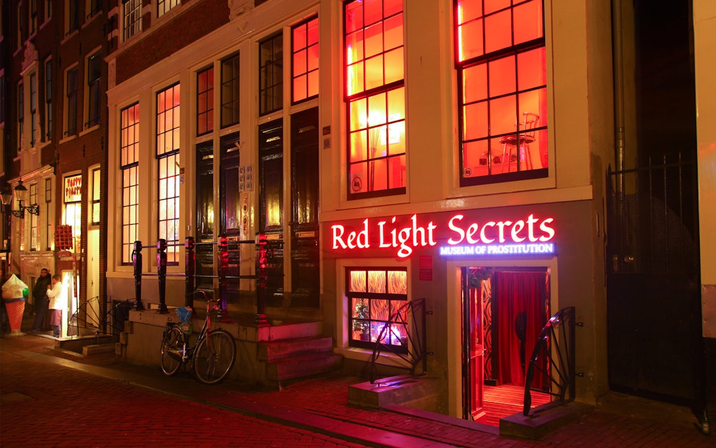 Red Light Secrets Museum entrance in Amsterdam's Red Light District at night.