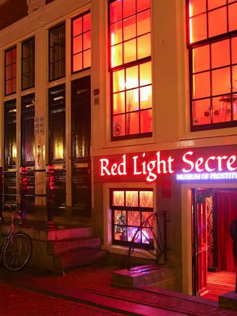 Red Light Secrets Museum entrance in Amsterdam's Red Light District at night.