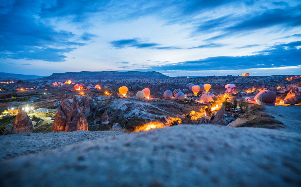 Hot air balloons preparing for flight at sunrise in Cappadocia, Turkey.