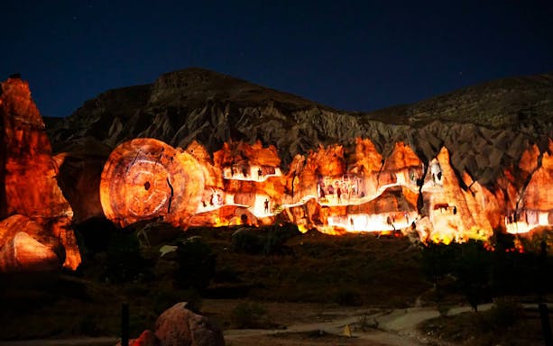Cappadocia rock formations illuminated at night during a small group tour with Goreme Open-Air Museum.