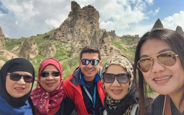 Tourists in front of rock formations at Goreme Open-Air Museum, Cappadocia.