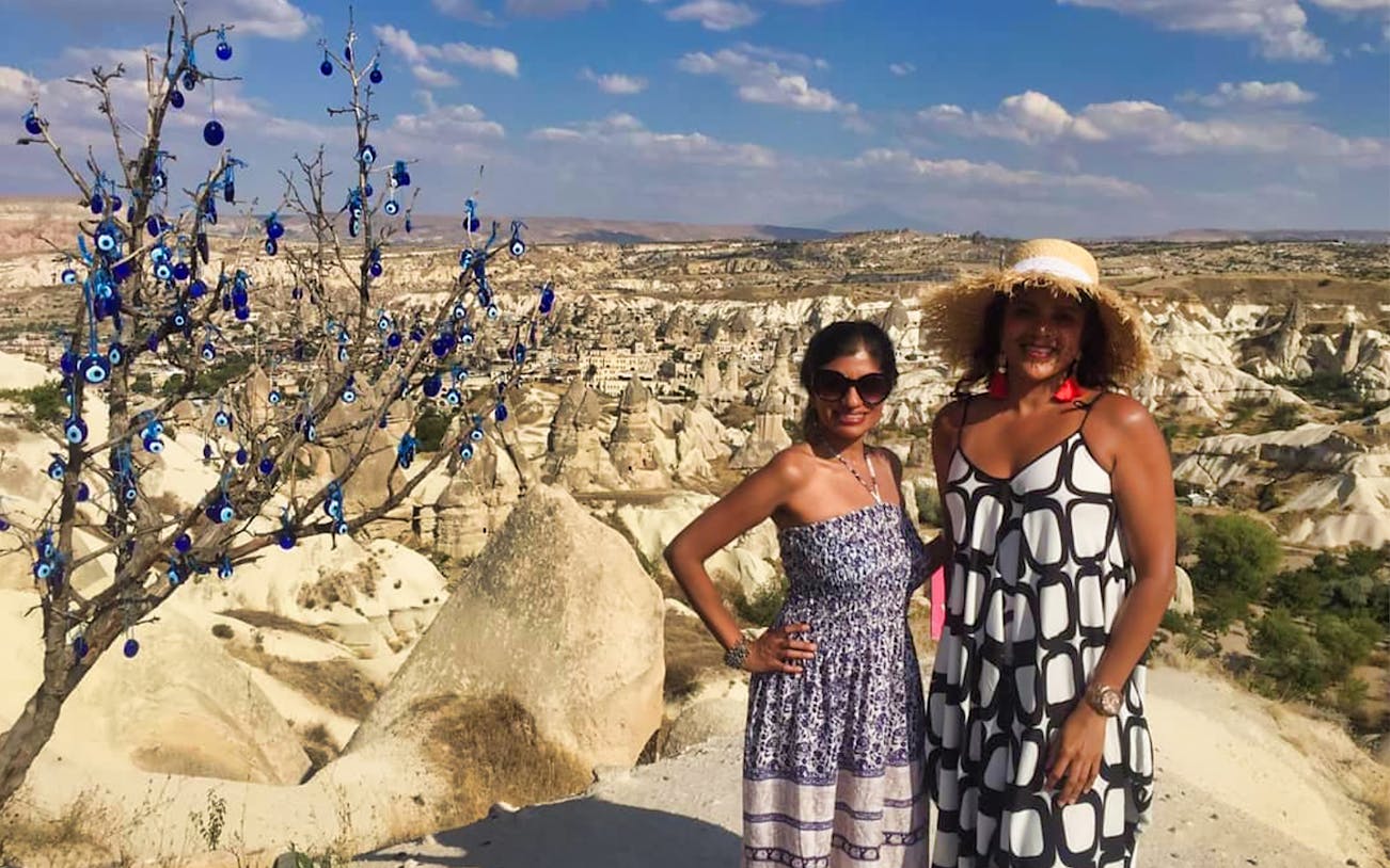 Cappadocia landscape with evil eye tree and Uchisar Castle in the background.