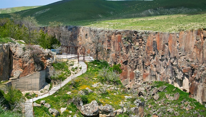 Pathway along Ihlara Valley canyon in South Cappadocia, surrounded by greenery and rock formations.
