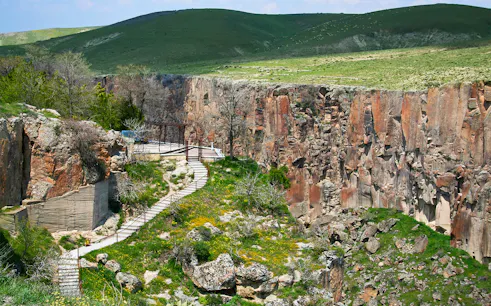 Pathway along Ihlara Valley canyon in South Cappadocia, surrounded by greenery and rock formations.