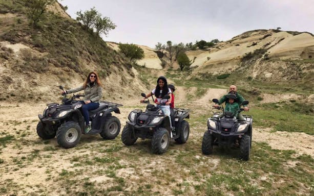 Group on quad bikes exploring rugged terrain during a safari tour.