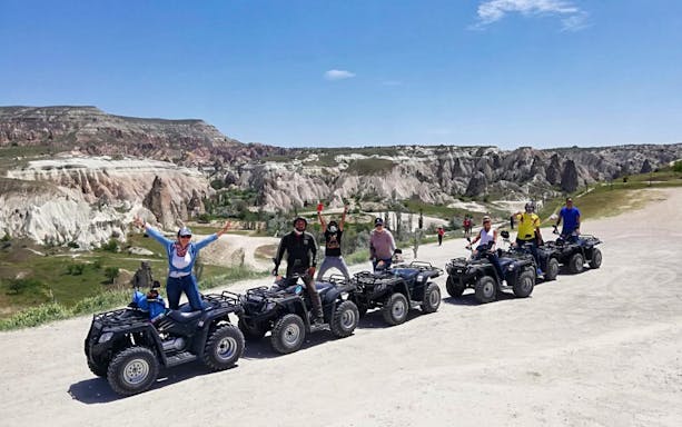 Group on quad bikes exploring rocky landscape during safari tour.