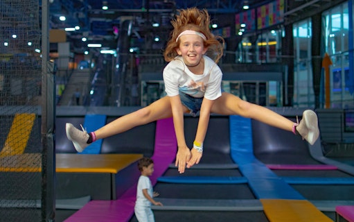 Child jumping on trampoline at Bounce Abu Dhabi indoor park.