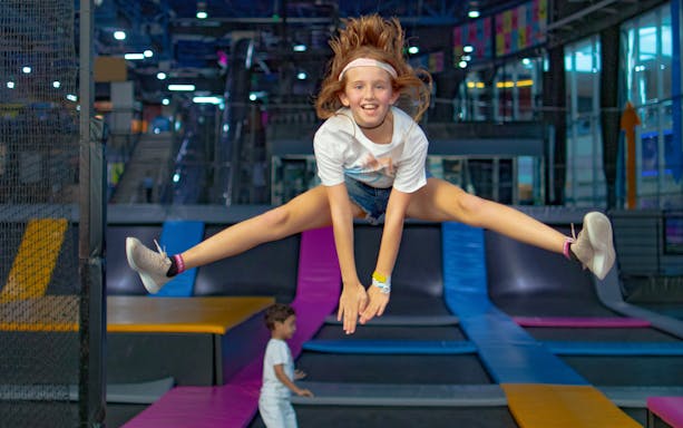 Child jumping on trampoline at Bounce Abu Dhabi indoor park.