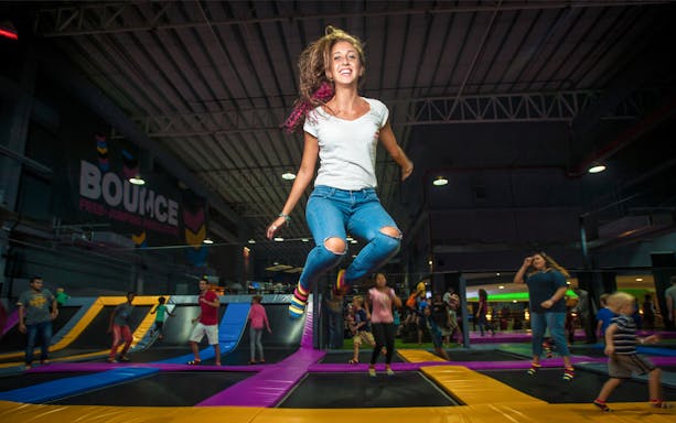 Person jumping on trampoline at Bounce Abu Dhabi indoor park.