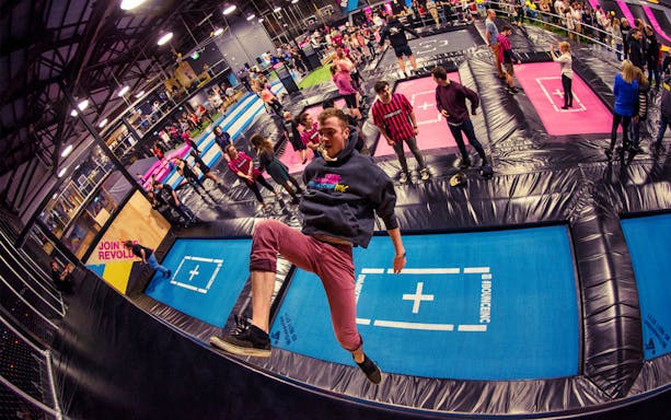 Person jumping on trampoline at Bounce Abu Dhabi indoor park.