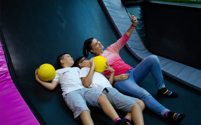 Family taking a selfie on trampoline at Bounce Abu Dhabi.