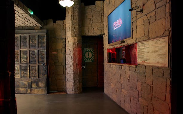 Entrance to Hysteria Haunted Attraction at Dubai Mall with stone walls and signage.
