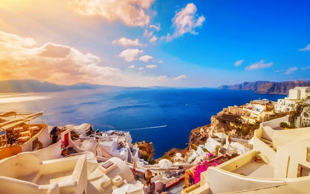 Santorini caldera view with white buildings and blue sea during morning boat tour.