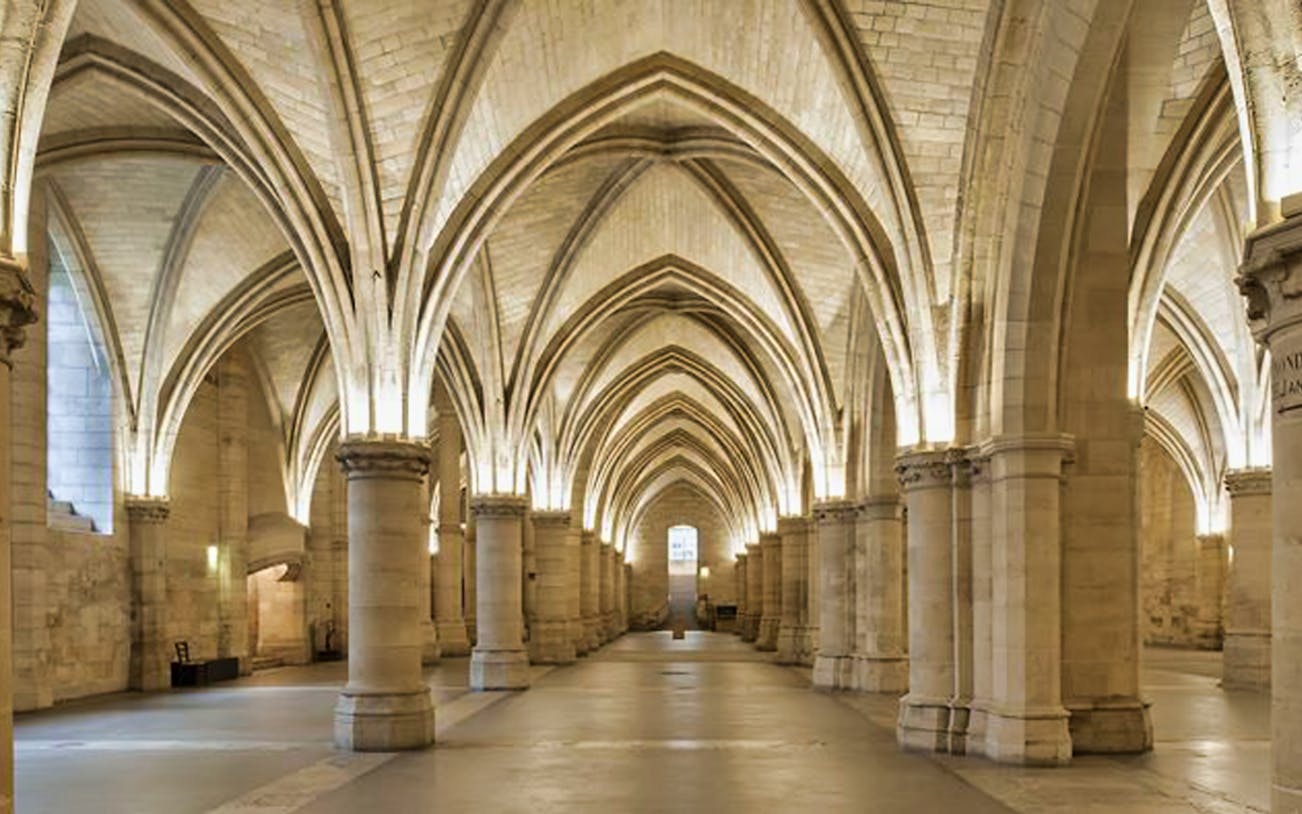 Conciergerie's Gothic vaulted hall in Paris, part of Seine River Cruise tour.