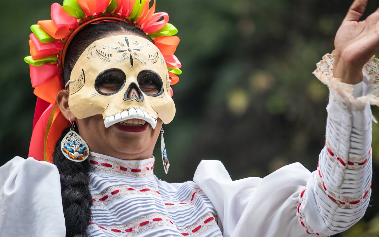 Tourists exploring Mexico City on the Day of the Dead, visiting vibrant street decorations and traditional celebrations
