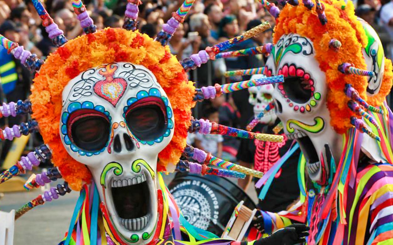 Day of the Dead parade in Mexico City with colorful costumes and traditional skull makeup.