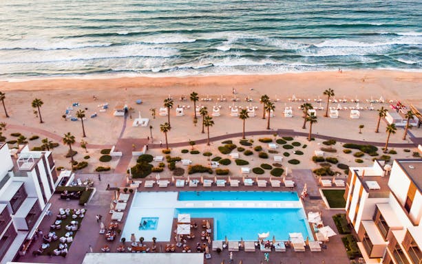 Aerial view of Nikki Beach Resort & Spa Dubai with pool, beach, and ocean.