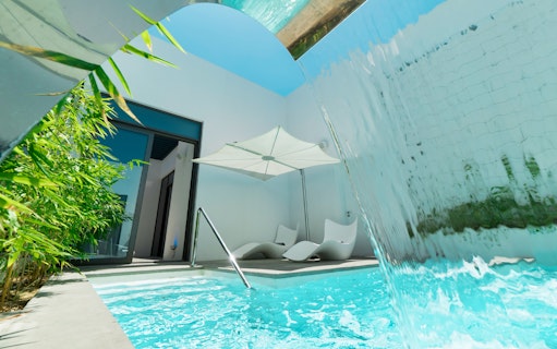 Private pool with waterfall and lounge chairs at Nikki Beach Resort & Spa Dubai.