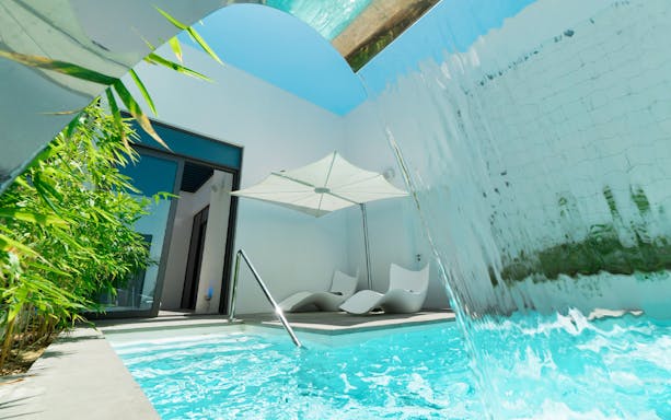 Private pool with waterfall and lounge chairs at Nikki Beach Resort & Spa Dubai.