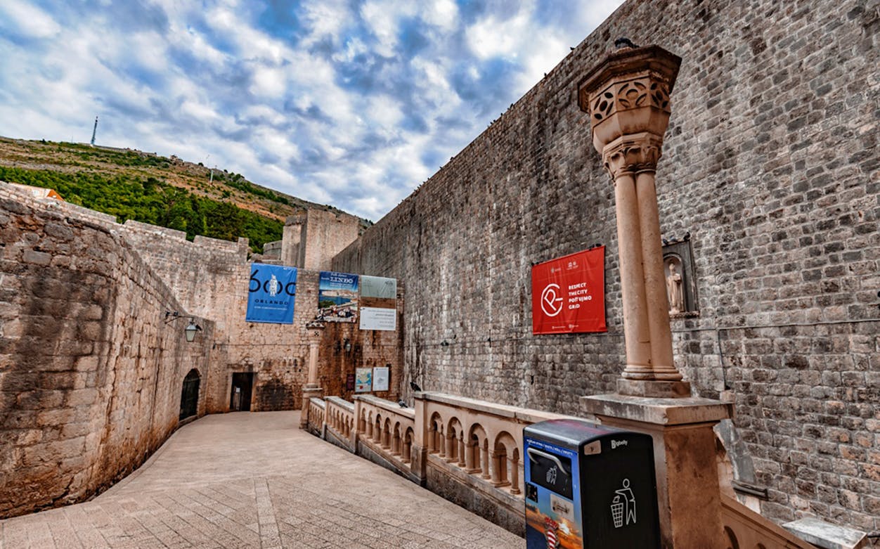 Dubrovnik Old Town stone walls with banners, part of Game of Thrones Walking Tour.