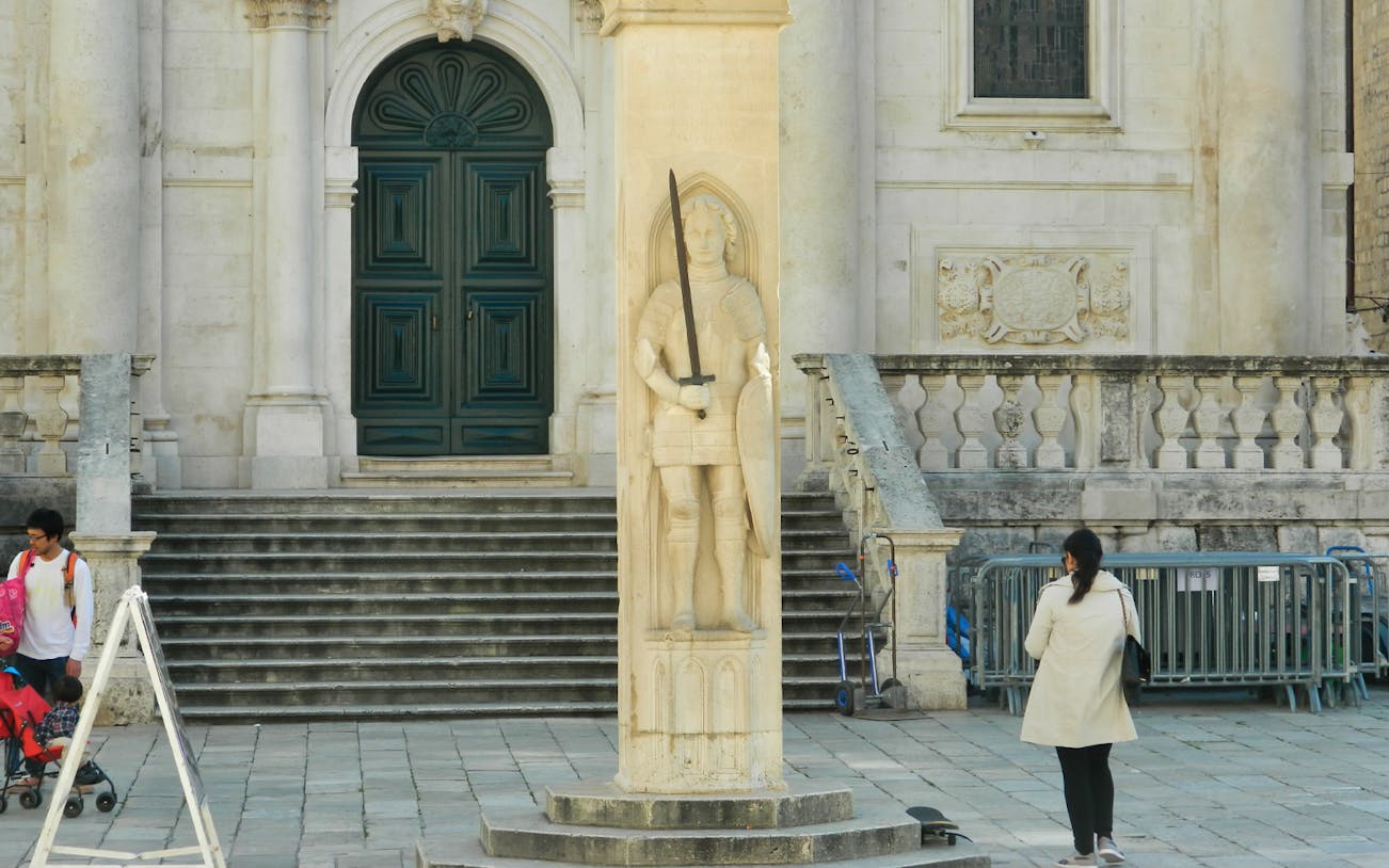 Statue of Orlando in front of a historic building in Dubrovnik.