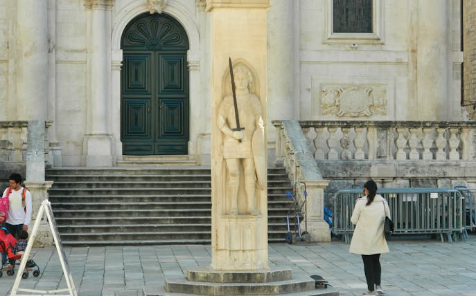 Statue of Orlando in front of a historic building in Dubrovnik.