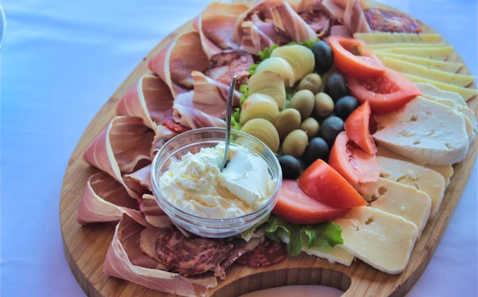 Charcuterie board with prosciutto, cheese, olives, and cream cheese on Dubrovnik Food & Market Tour.