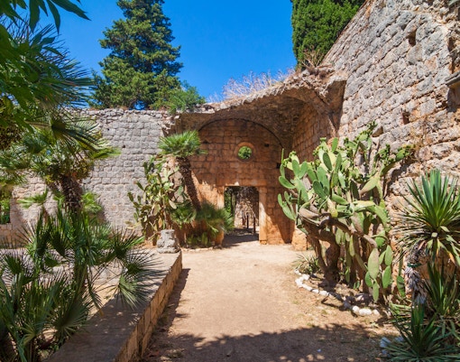 Stone archway and lush greenery on Game of Thrones boat tour in Dubrovnik, Croatia.