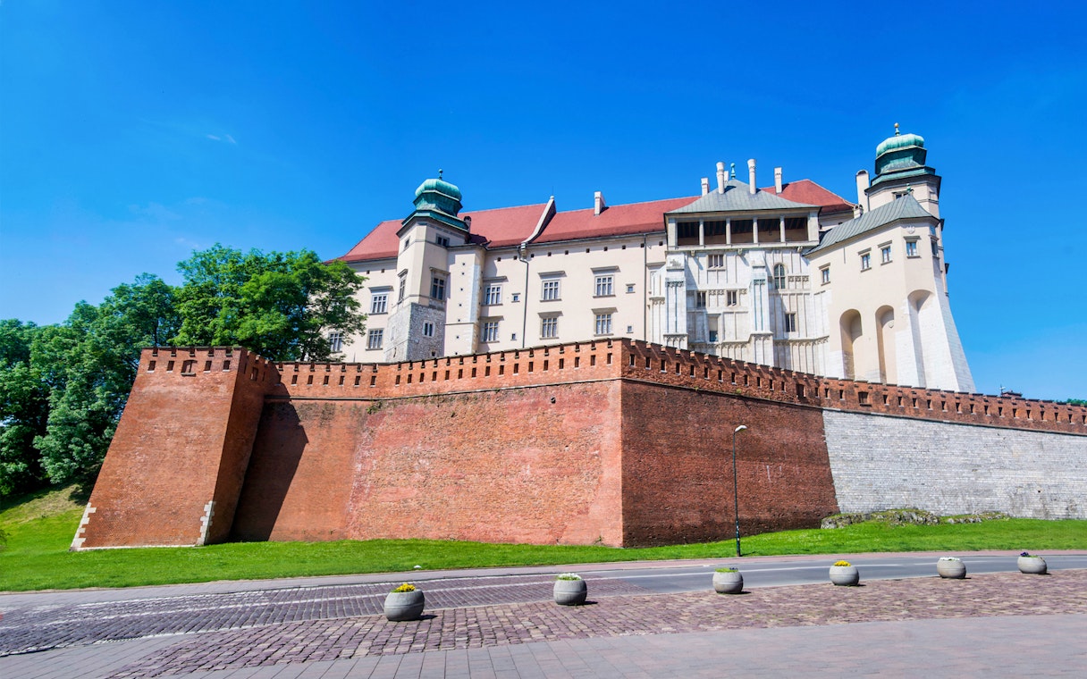 Wawel Castle on Wawel Hill, Krakow, viewed from below with red brick walls.