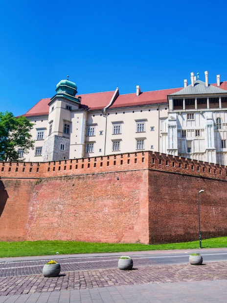 Wawel Castle on Wawel Hill, Krakow, viewed from below with red brick walls.