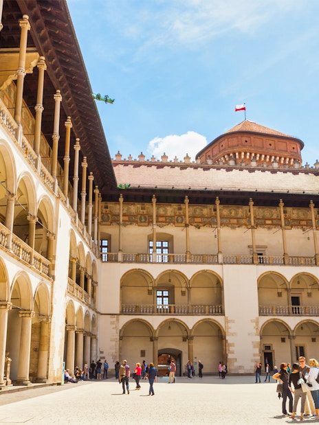 Wawel Royal Castle courtyard with tourists on a guided tour in Krakow, Poland.