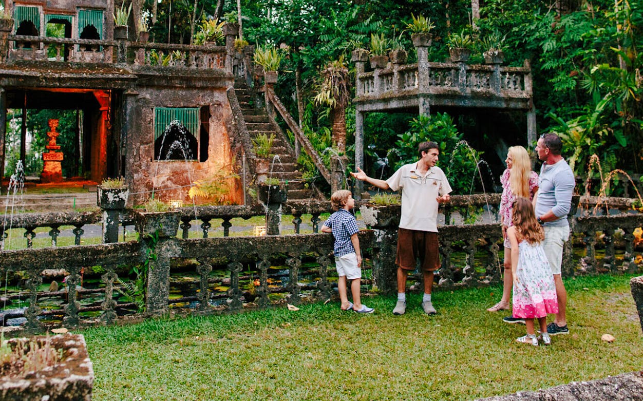 Guide explaining Paronella Park's historic architecture to a family in Queensland, Australia.