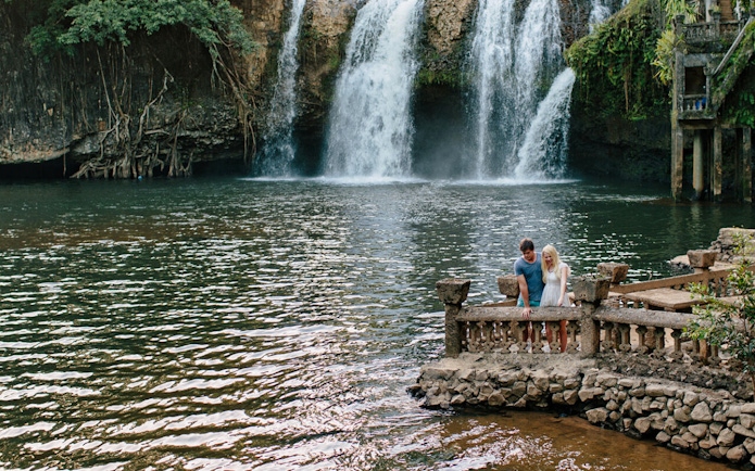Couple enjoying the view of a waterfall at Paronella Park, Australia.