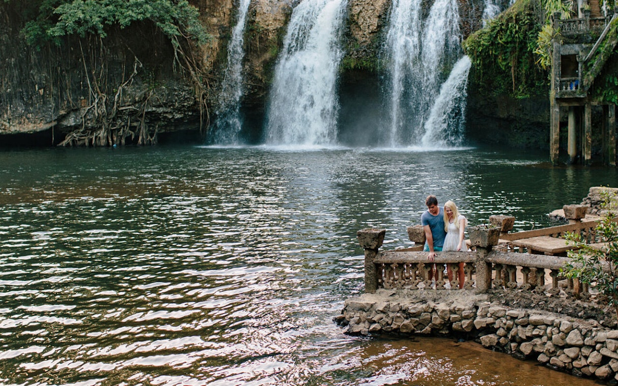 Couple enjoying the view of a waterfall at Paronella Park, Australia.