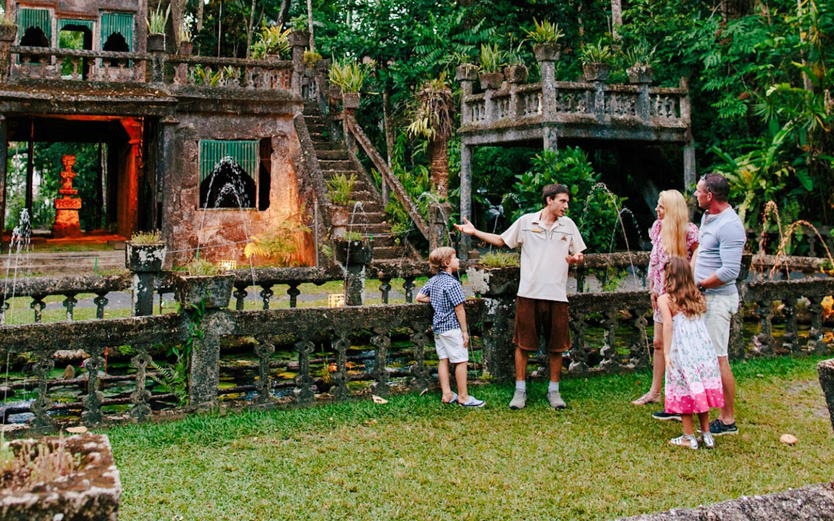 Guide explaining Paronella Park's historic architecture to visitors.