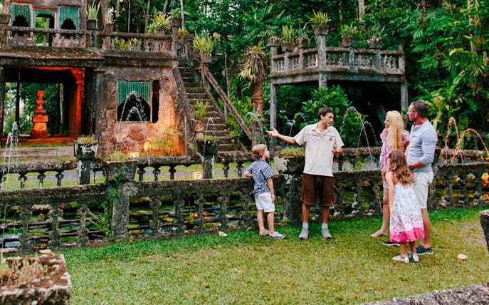 Guide explaining Paronella Park's historic architecture to visitors.