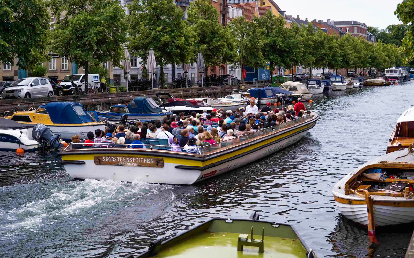 Copenhagen canal boat tour passing colorful Nyhavn buildings, part of The Grand Tour from Ved Stranden.