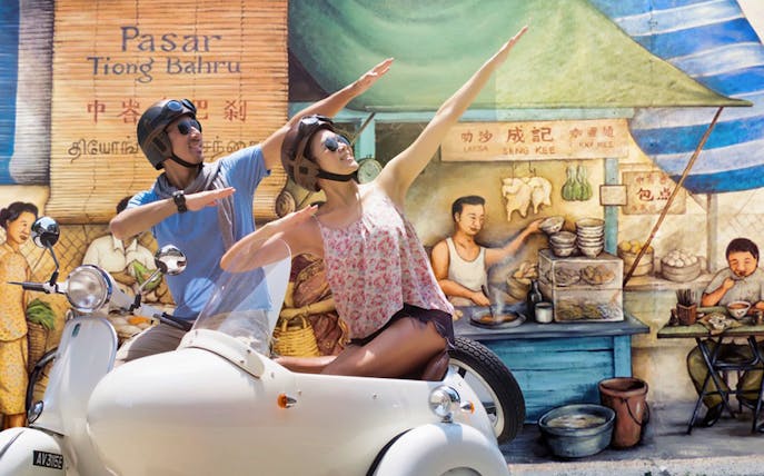 Tourists on a sidecar in front of Tiong Bahru mural during Singapore Sidecar Tour.