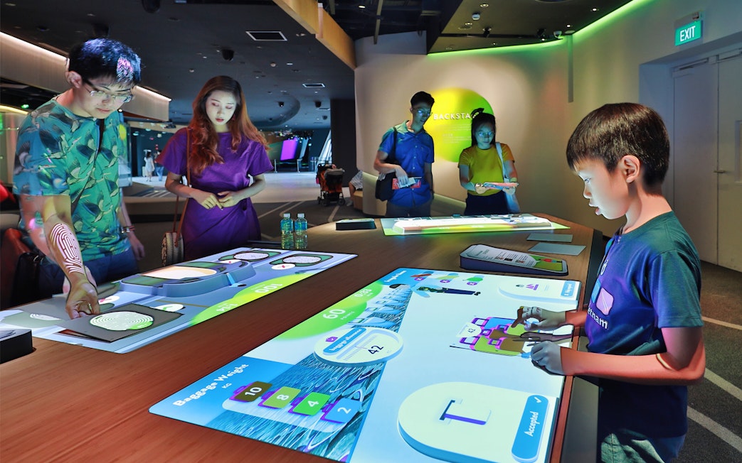 Visitors interacting with digital displays at Changi Experience Studio.