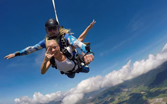 Tandem skydive over Cairns at 15,000ft with scenic view of clouds and landscape below.