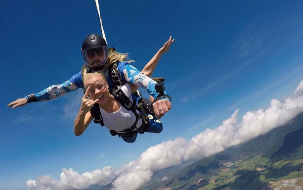 Tandem skydive over Cairns at 15,000ft with scenic view of clouds and landscape below.