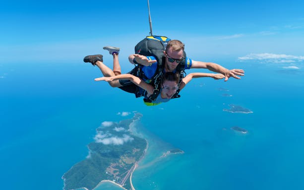 Tandem skydive over Mission Beach, Australia, with ocean and islands below.